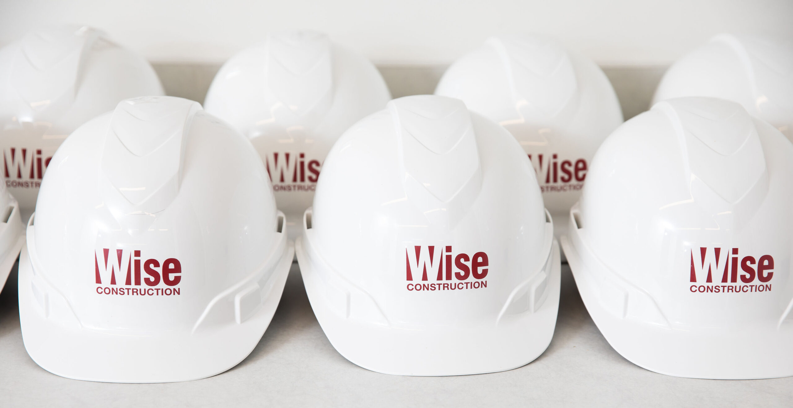 Wise Construction hard hats lined up on a table.
