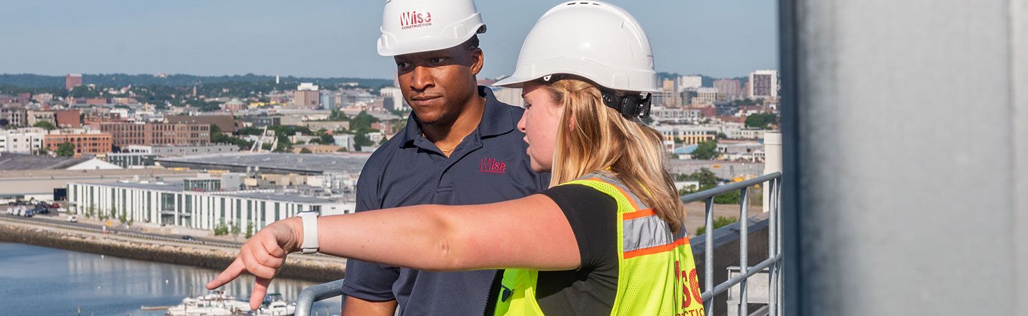 A Black Wise employee and a white woman Wise employee discuss a job site