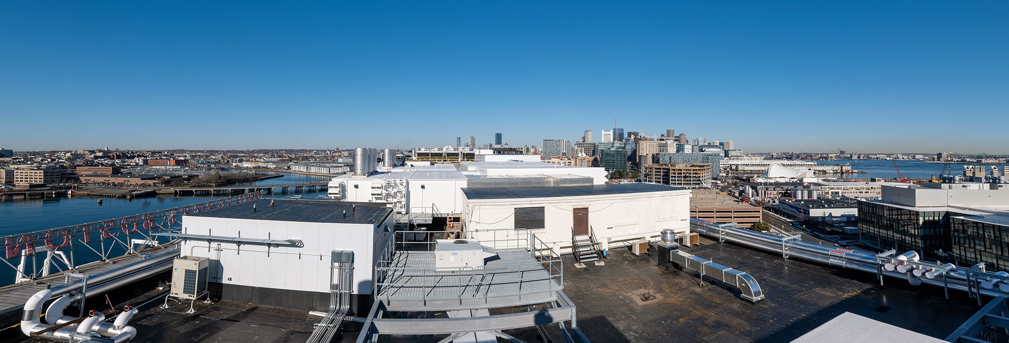 Panoramic rooftop view of HVAC and city skyline.